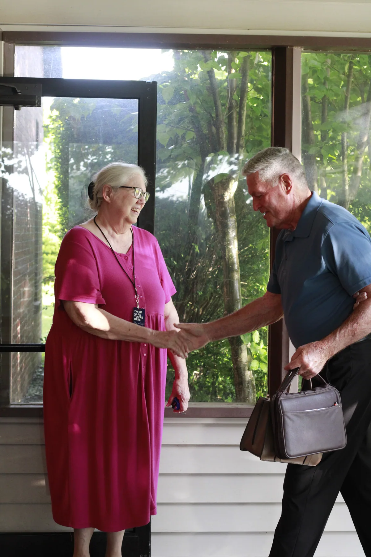 A greeter shaking hands with a guest at the door before service