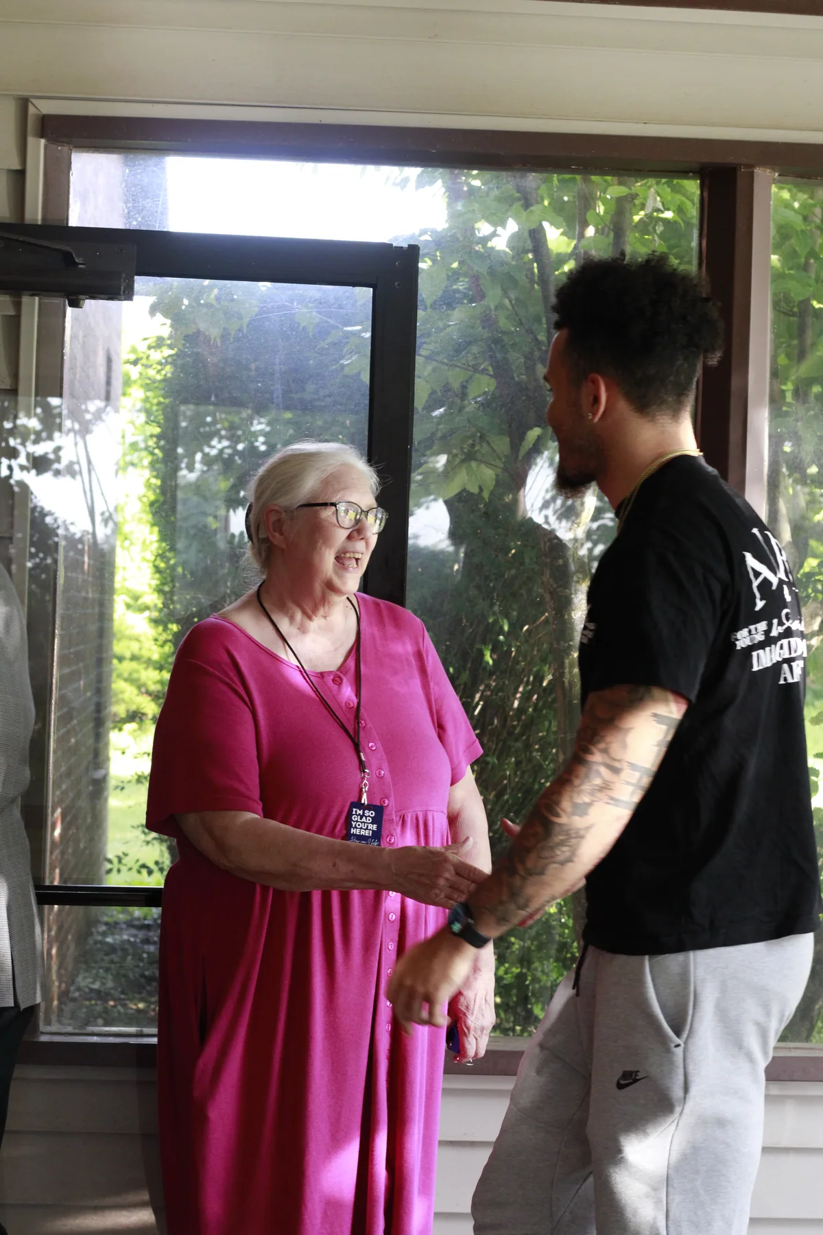 A member shaking hands with a guest in the doorway before service