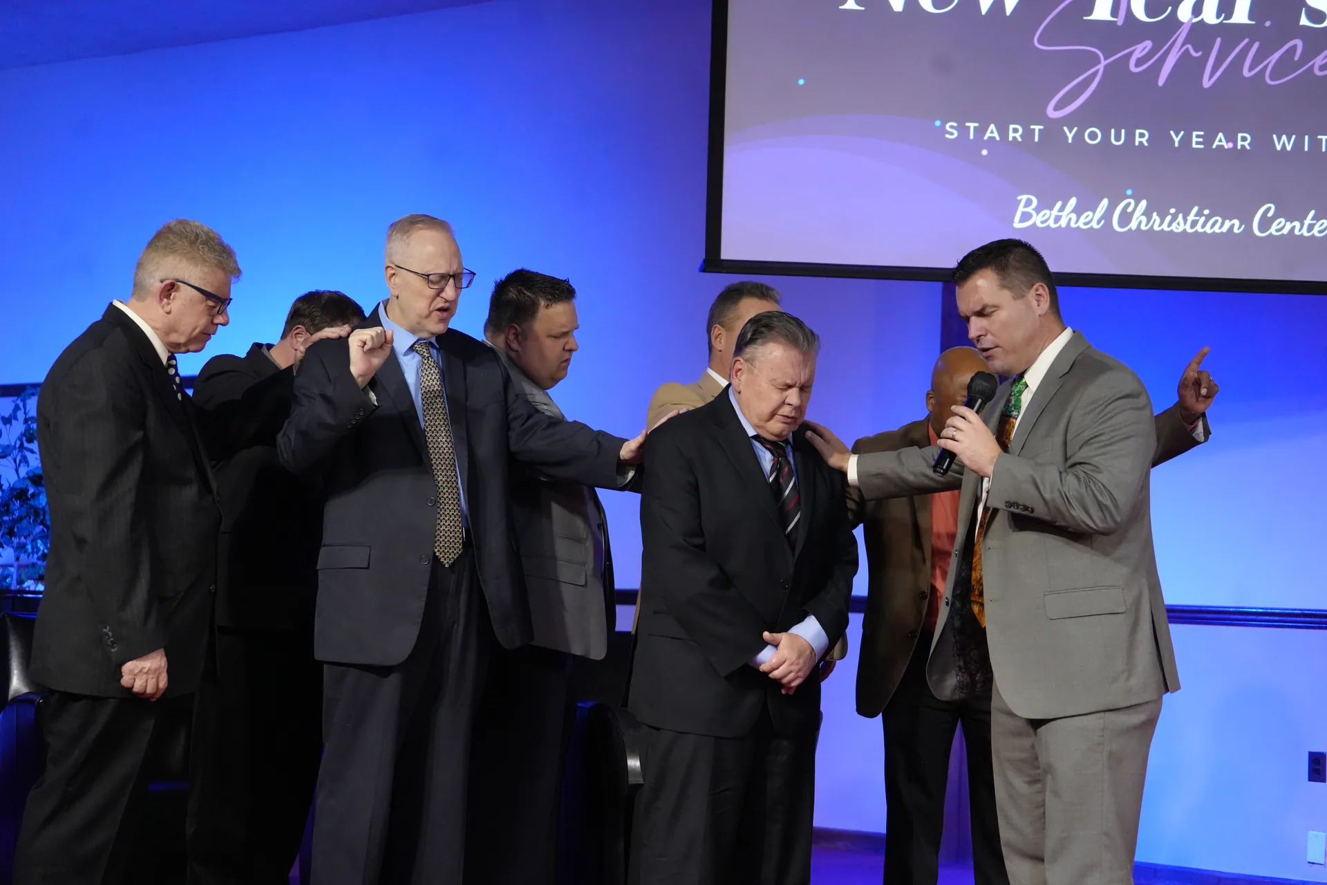Ministers praying together at the front of the sanctuary