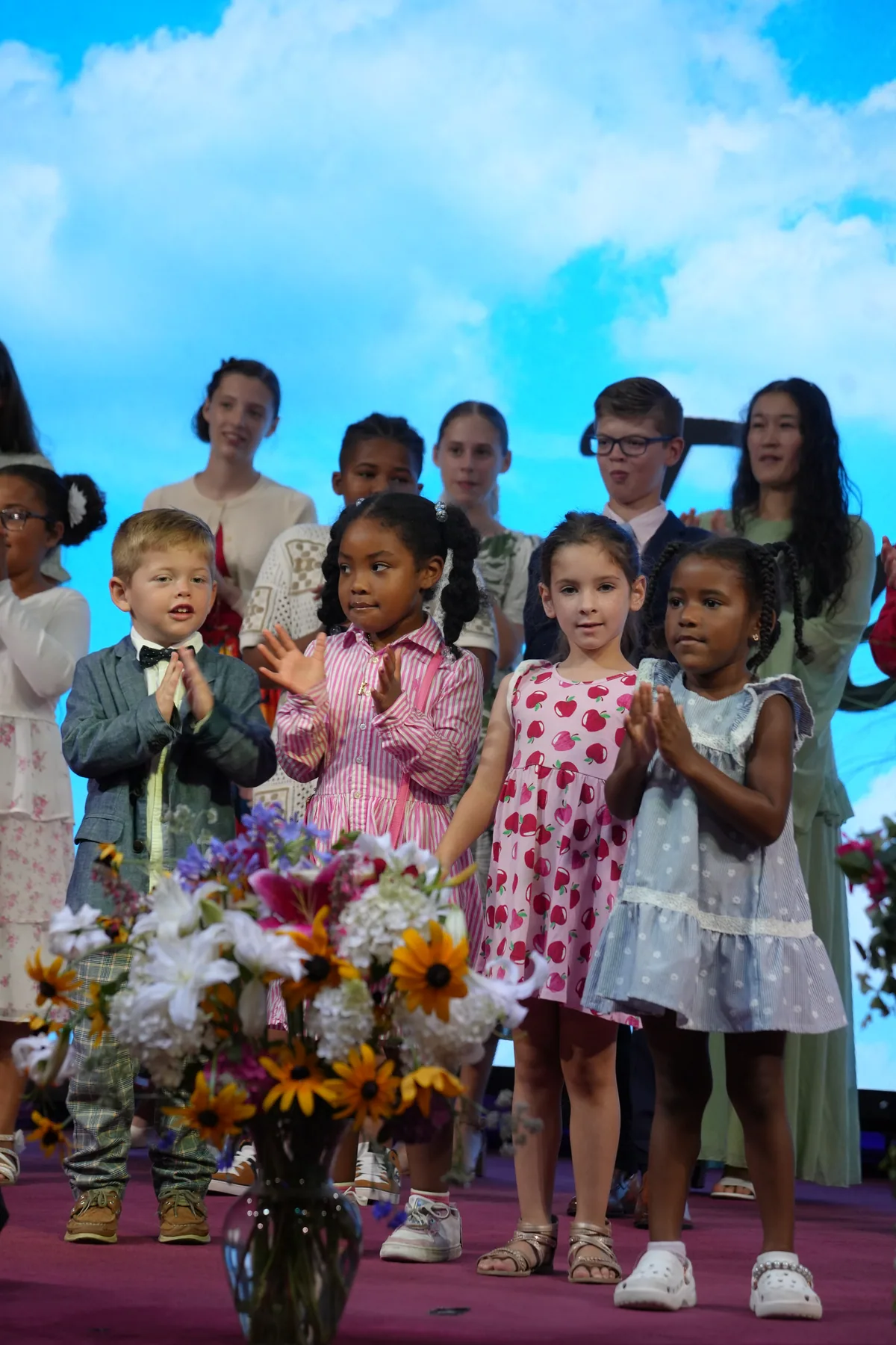 Children of Bethel gathered at the front of the sanctuary with flowers
